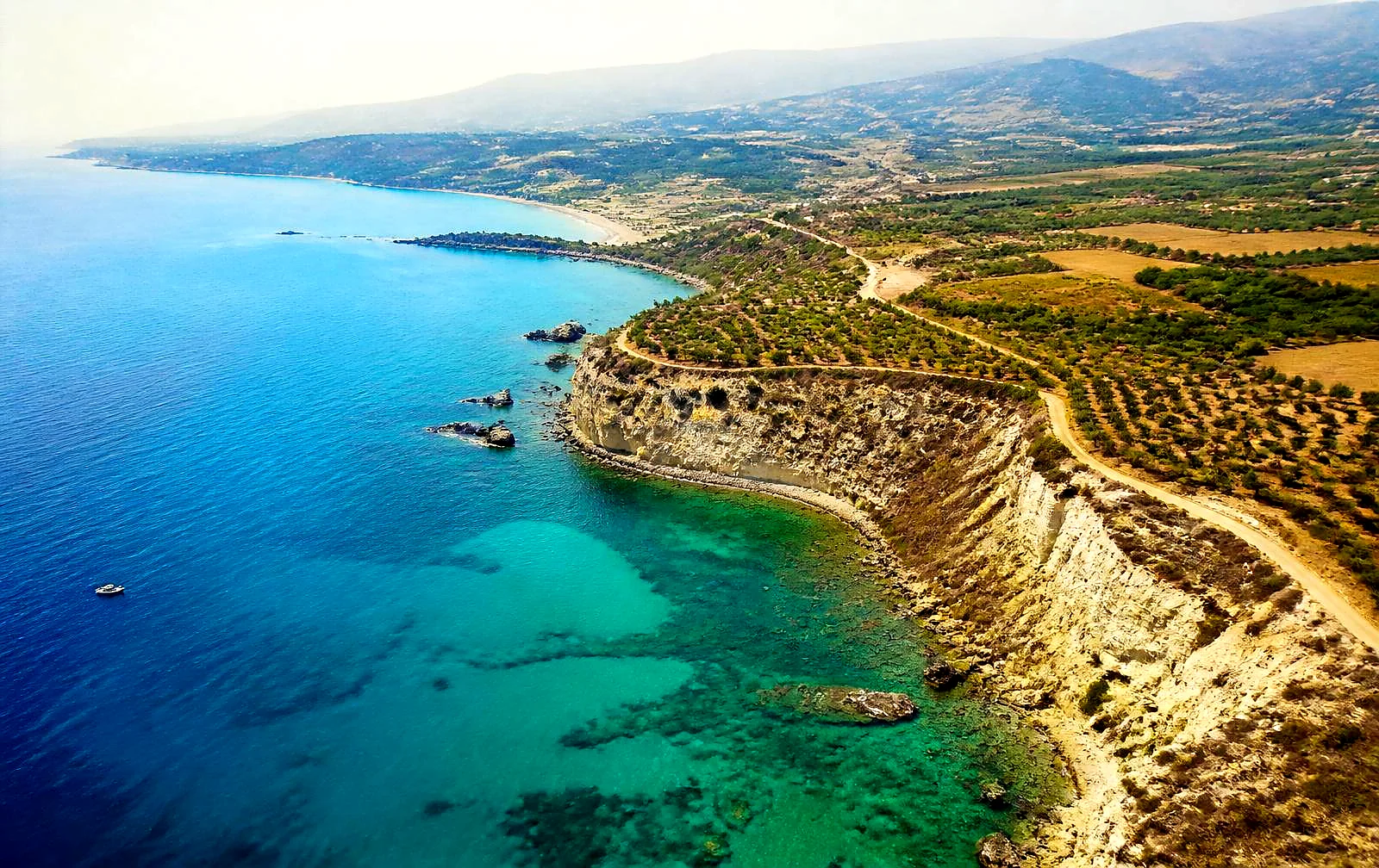 Aerial view of the Cyprus coastline with turquoise bays, cliffs and olive groves